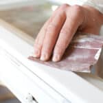 Sanding aluminium windows to prep for painting.